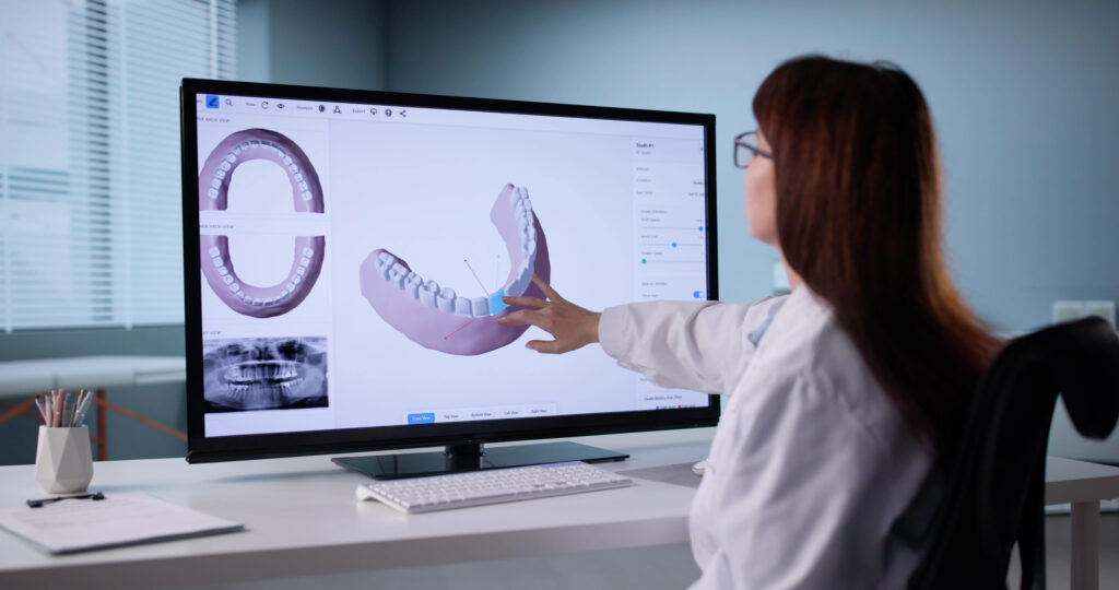 Female Orthodontist Using 3D Technology To Plan Dental Treatment